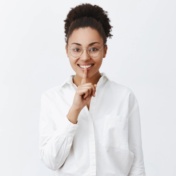 Mujer sonriendo con el dedo en la barbilla