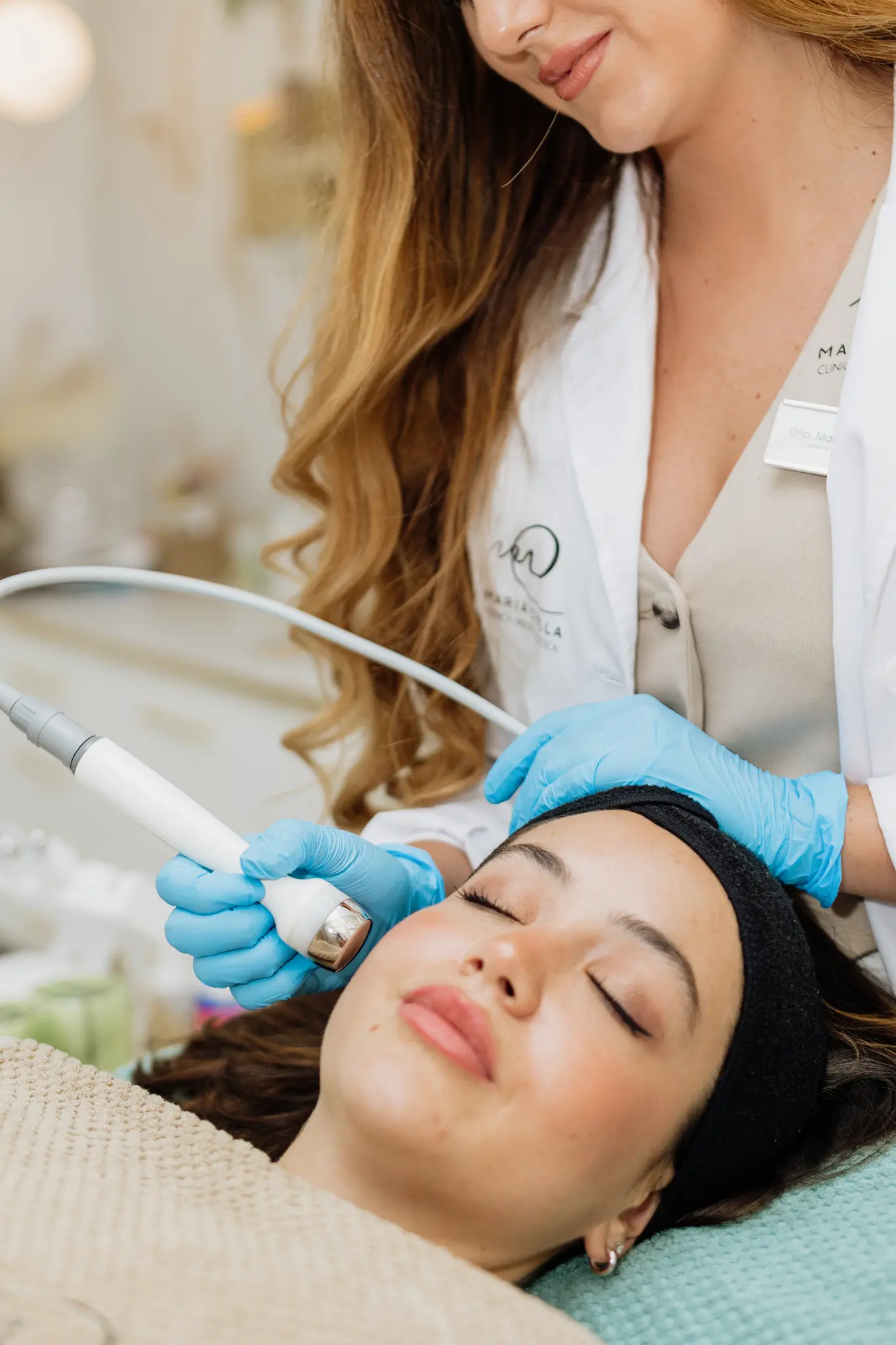 Profesional realizando tratamiento facial con aparatología a una paciente